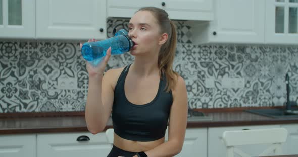 Beautiful Woman Drinking Water and Resting After Training at Home. Healthy Lifestyle New Normal alt