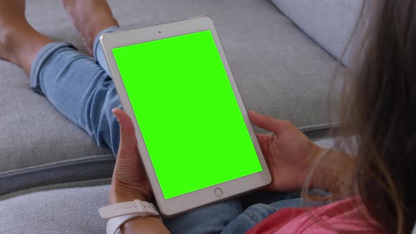 Young Caucasian woman using digital tablet in living room at home 4k alt