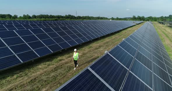 Aerial Shot of Three Solar Energy Engineer on a Large Solar Farm alt