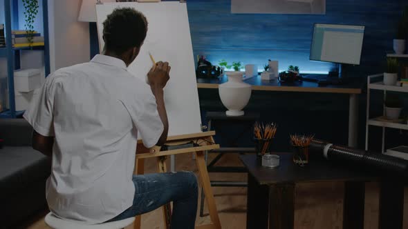 African American Artist Working on White Canvas with Drawing alt