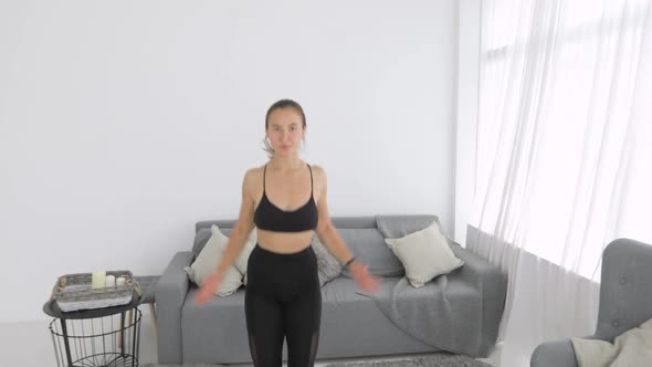 Woman Is Doing Jumping Jeg Exercise on Carpet in Living Room, Camera Moves Away.