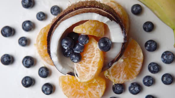 The Blueberry and Orange Slices Inside of Half of Coconut