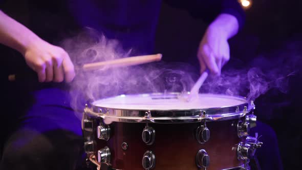 Drummer playing snare drum with smoke and beautiful lighting close up.