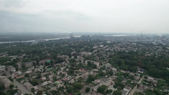 Aerial View of the City Near a Large Industrial Plant with Pipes and Smoke alt