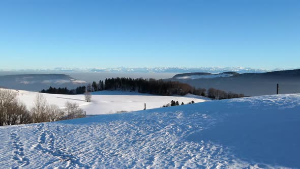 drone flight through the snow on a mountain top in winter