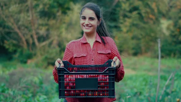 Young caucasian woman farmer stands in a field alt