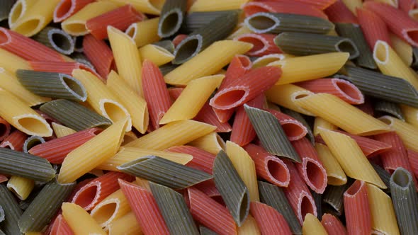 Tri-color penne pasta, Tomato, spinach and wheat pastas, Rotating on a table