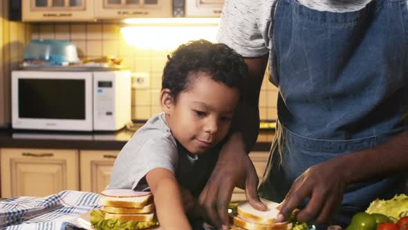 Biracial boy trying to make super skyscraper sandwich