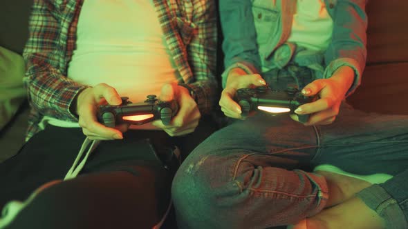 Hands of a Man and Girl Holding a Joysticks to Play Video Games on TV alt
