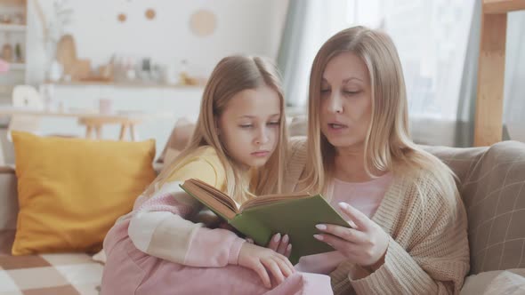 Woman Reading Book to Her Daughter alt