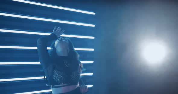 Beautiful Girl Dancing Seductively in a Dark Studio with Smoke alt