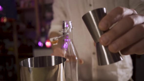 The Bartender Pouring Sugar Syrup From a Jigger Into a Shaker alt