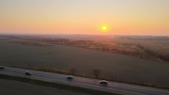 Aerial View of Intercity Road with Fast Driving Cars at Sunset alt