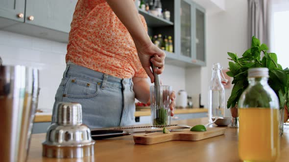 Woman Making Mojito Cocktail Drink at Home Kitchen alt