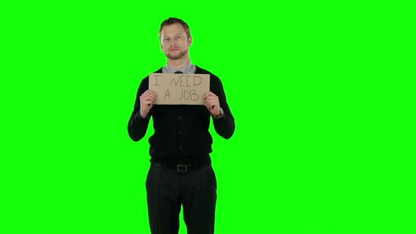 Businessman with a Cardboard Sign That Asks About Desire To Find a Job. Green Screen alt