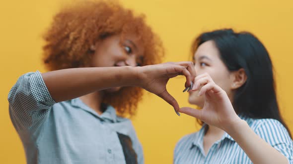 Multiracian Homosexual Relationship Concept. African American Black and Asian Woman Making Hearts alt