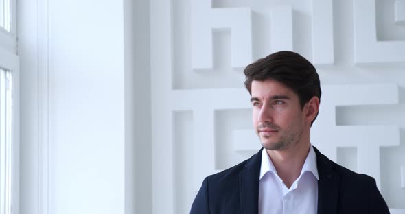 Portrait of Young Confident Business Man Looking at the Window in Modern Office alt