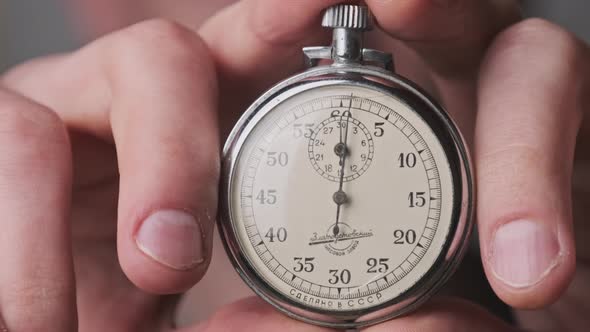 Stopwatch in Male Hand Counts Down Seconds alt