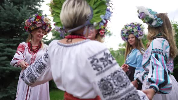 Medium Shot Portrait of Smiling Ukrainian Woman Standing Outdoors Admiring Young Ladies Walking alt