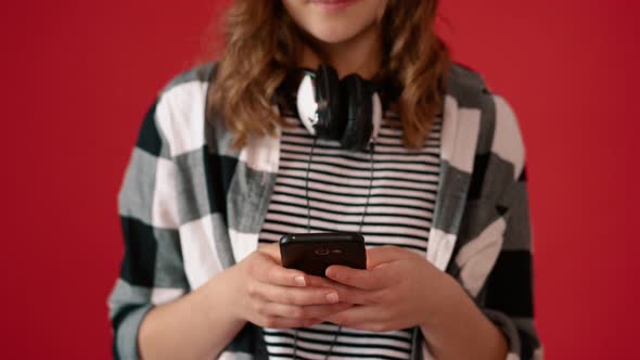 Girl Teenager Using Smartphone on Red Background