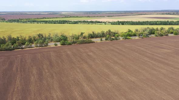 Highway and agricultural fields aerial view, Trucks are moving along the highway