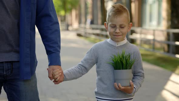 Close View of the Father Holding Sons Hand and Son is Holding the Plant in a Pot After Ecology alt