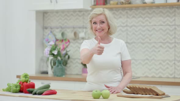 Senior Old Woman Showing Thumbs Up While Standing in Kitchen alt