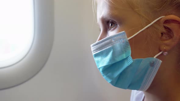 Masked child at the plane window