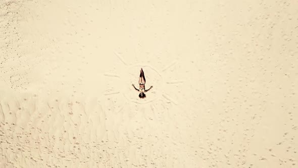 Happy free caucasian woman lay down on the sand at the beach alt