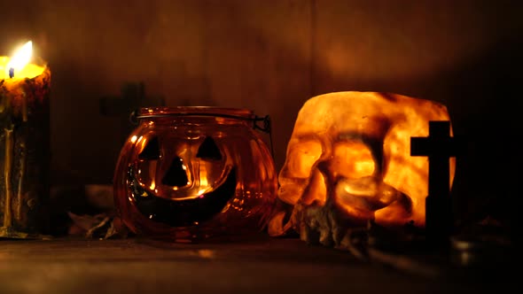 The concept of the Halloween festival with the orange pumpkin, candle light, and the bone skull