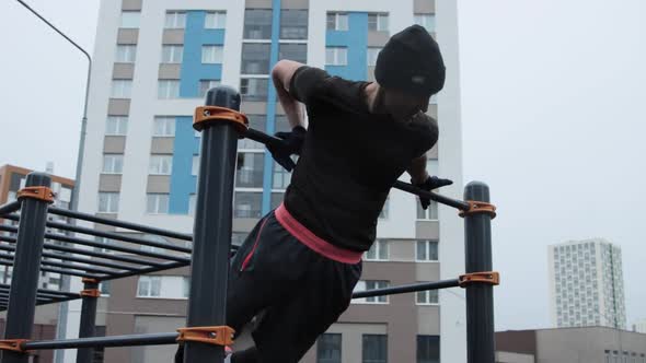 Muscular man training outdoors on sports field