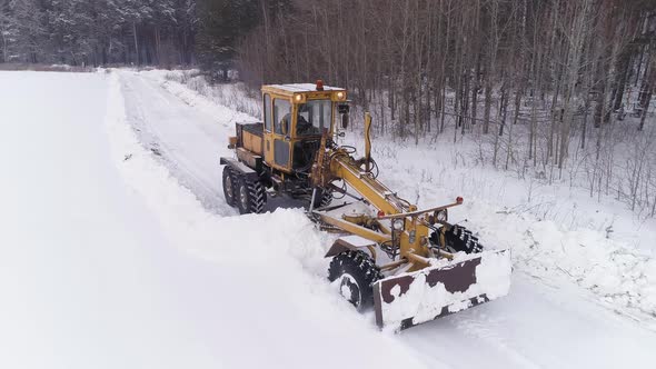 Aerial view of Snowblower Grader Clears Snow Covered Road next to the forest 14 alt