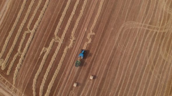 Drone Over Head View Of Tractor, Bailing Straw In Field