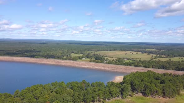 Cars Driving Across a Lake Dam alt