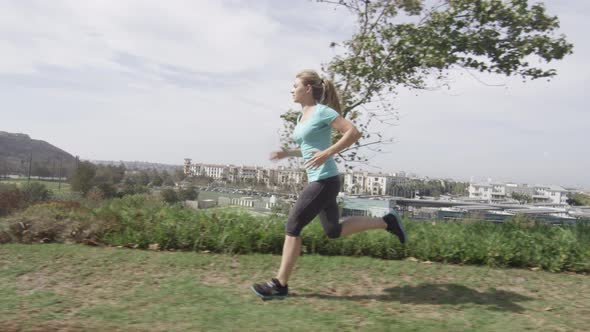 A young woman runner going for a run in a residential neighborhood. alt