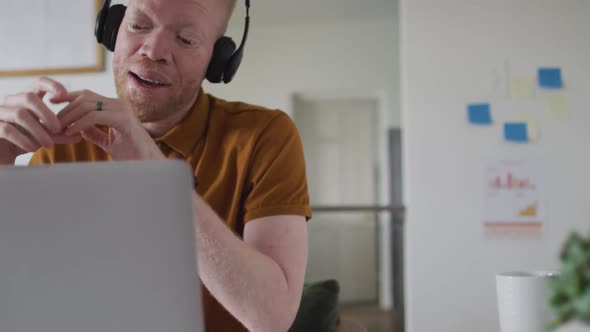 Albino african american man with dreadlocks making video call on the laptop alt