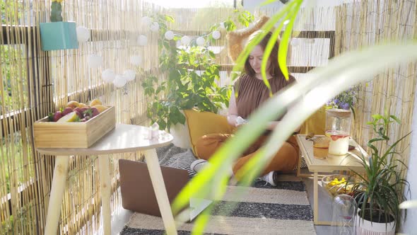 Young Woman Meditates on Sunny Terrace