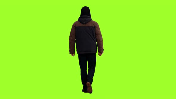 Rear View of Adult Man Walks in Winter Clothes 