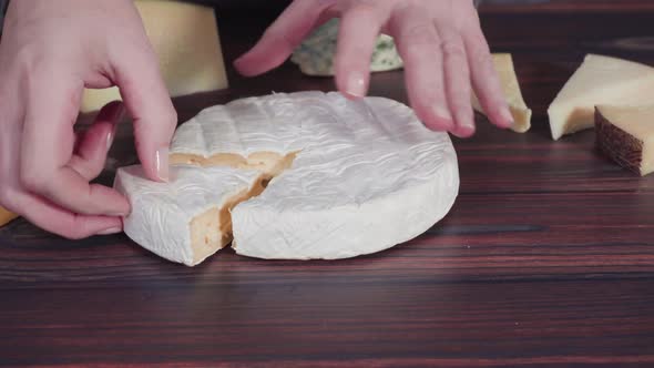 Time lapse. Large wedges of gourmet cheese on a rustic wood background. alt