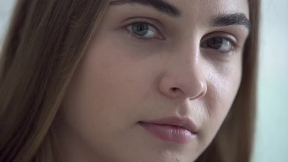 Close-up Portrait of Young Pretty Woman with Different Colored Eyes Looking at Camera in the Morning alt