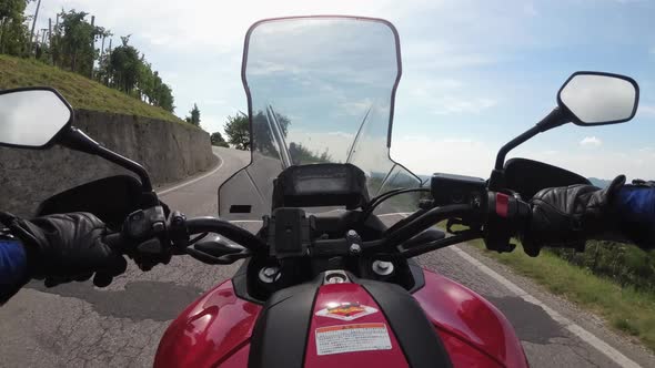POV Biker Rides on a Motorbike Between Fields of Vineyards in Italy Countryside alt