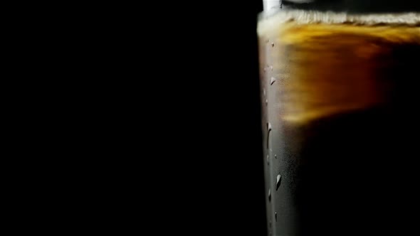 Glass With Whiskey And Soda And Ice Cubes That Interfere In The Left On A Black Background