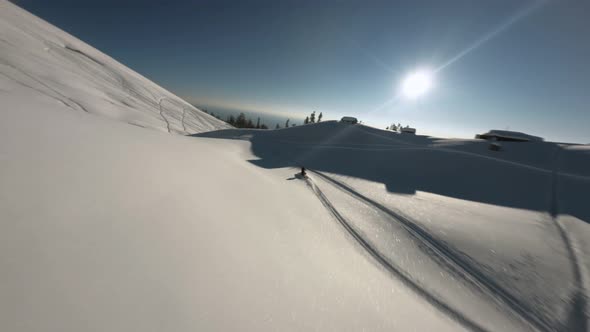 Aerial View Man Extreme Riding on Snowmobile Surrounded By Snowy Slope Mountain alt