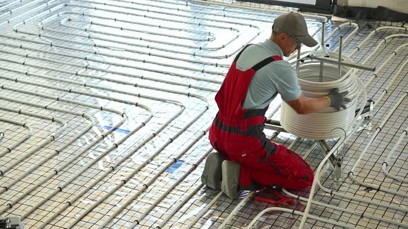Floor Radiant Heating Systems installation Inside a House Performed by Professional HVAC Worker alt