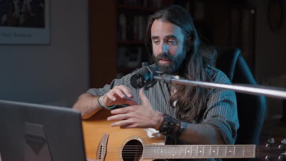 Young Handsome Musician Teaching Online the Technique to Play the Guitar alt