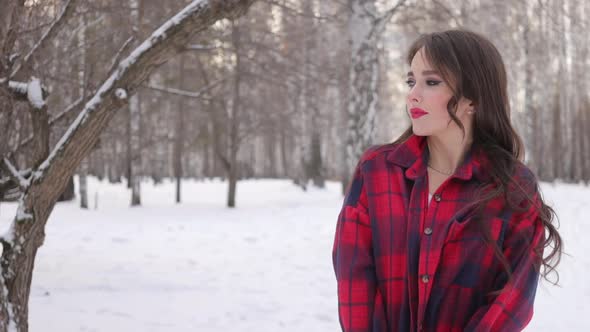 Charming Female with Long Hair Walking in Snowy Forest