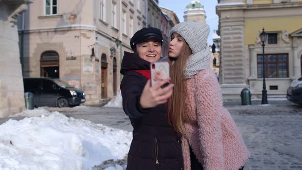 Sisters Couple Bloggers Taking Selfie Making Video Conferencing Call on Mobile Phone on City Street alt