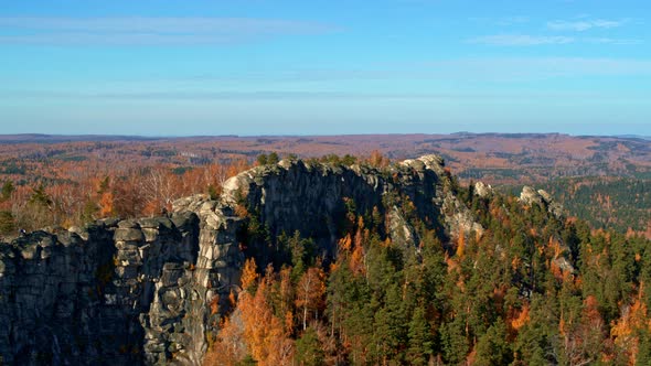 A Rock with an Autumn Forest on the Slopes