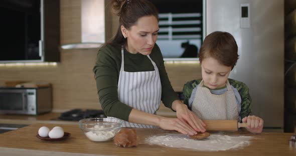 Mother and Little Son Making Handmade Cookies at Home Rolling Raw Dough Together at Kitchen alt