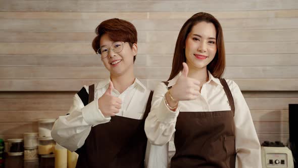 lgbt couples who are baristas and business owners being Thumbs up shows confidence